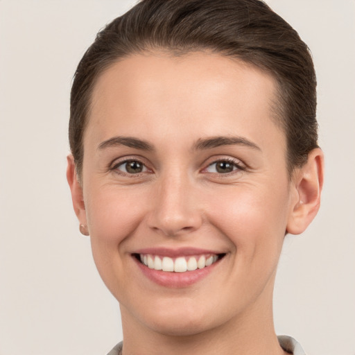 Joyful white young-adult female with short  brown hair and brown eyes