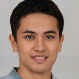 Joyful asian young-adult male with short  brown hair and brown eyes