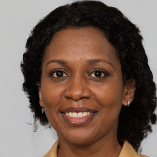 Joyful black adult female with medium  brown hair and brown eyes