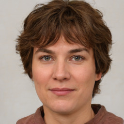 Joyful white adult female with medium  brown hair and green eyes