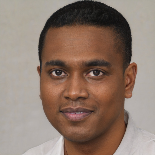 Joyful black young-adult male with short  black hair and brown eyes