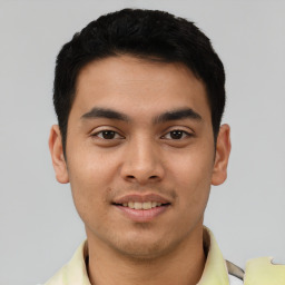 Joyful latino young-adult male with short  black hair and brown eyes