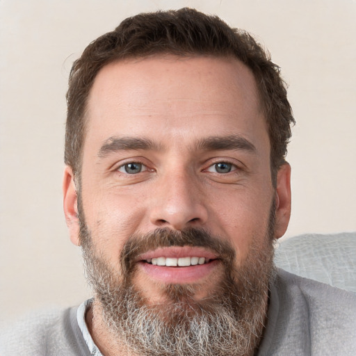 Joyful white adult male with short  brown hair and grey eyes