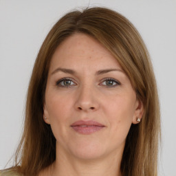 Joyful white adult female with long  brown hair and grey eyes