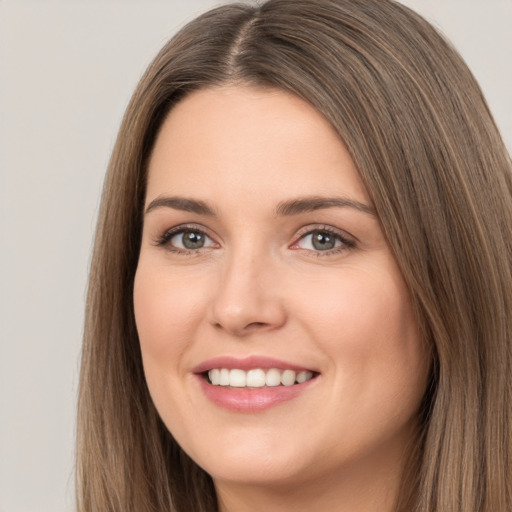 Joyful white young-adult female with long  brown hair and brown eyes