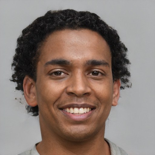Joyful black young-adult male with short  brown hair and brown eyes