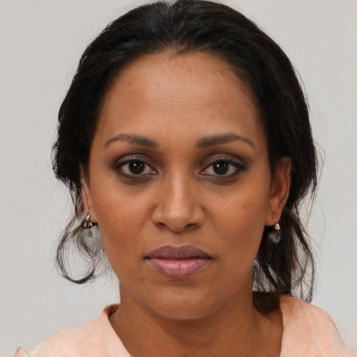 Joyful black adult female with medium  brown hair and brown eyes
