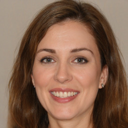 Joyful white adult female with medium  brown hair and brown eyes