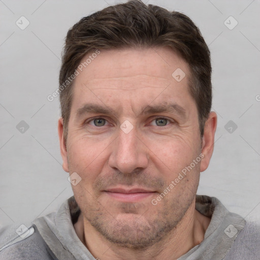 Joyful white adult male with short  brown hair and grey eyes