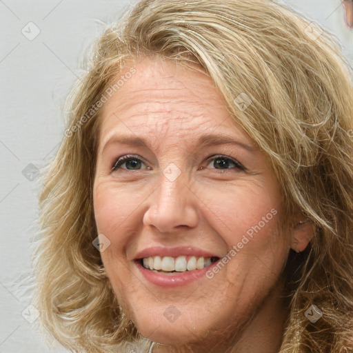 Joyful white adult female with medium  brown hair and green eyes