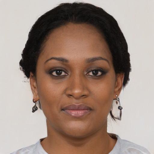 Joyful black young-adult female with short  black hair and brown eyes