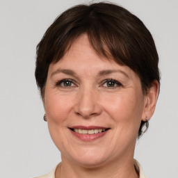 Joyful white adult female with medium  brown hair and grey eyes