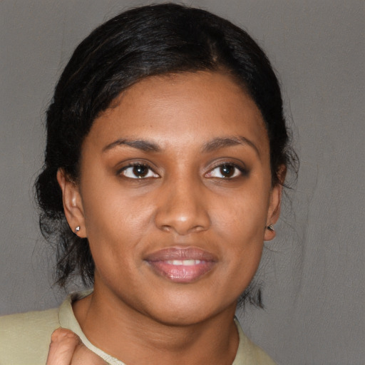 Joyful black young-adult female with medium  brown hair and brown eyes