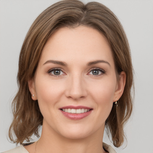 Joyful white young-adult female with medium  brown hair and green eyes