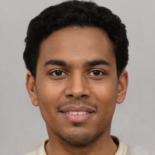 Joyful latino young-adult male with short  black hair and brown eyes