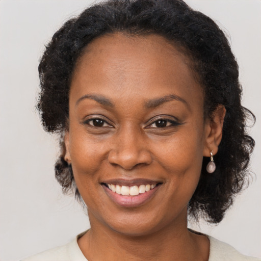 Joyful black adult female with short  brown hair and brown eyes