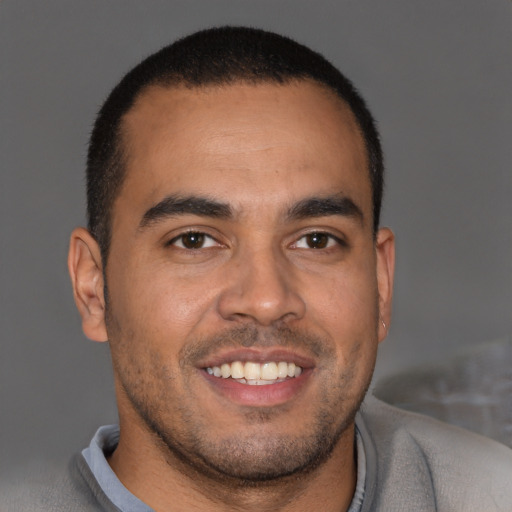 Joyful latino young-adult male with short  brown hair and brown eyes