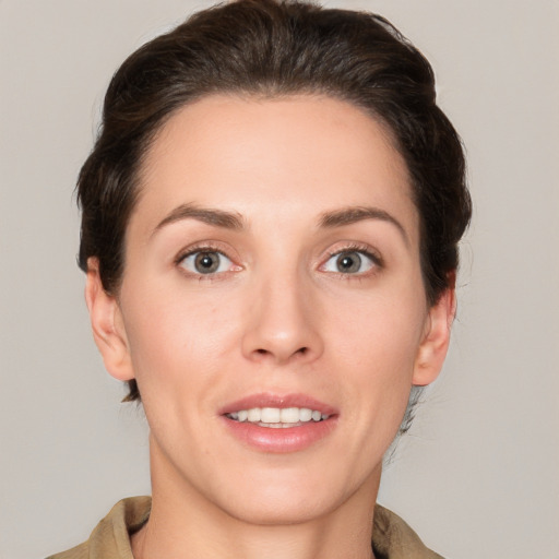 Joyful white young-adult female with short  brown hair and grey eyes