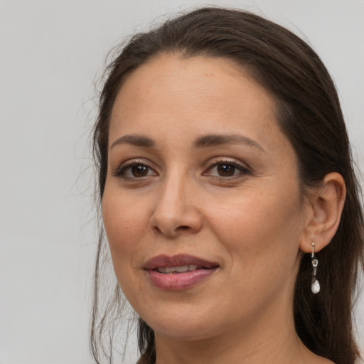 Joyful white adult female with long  brown hair and brown eyes