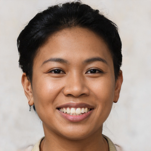 Joyful latino young-adult female with short  black hair and brown eyes