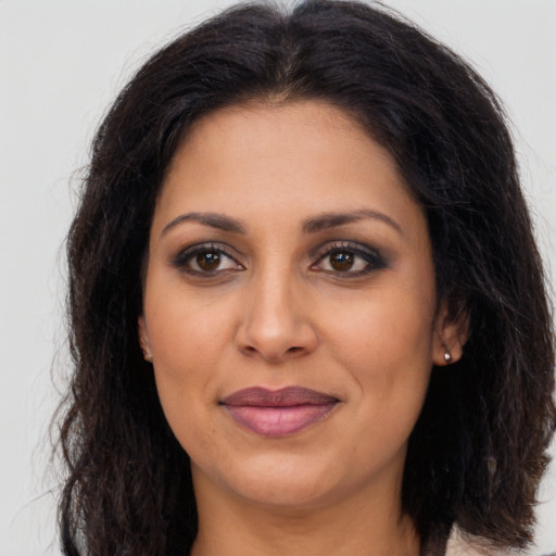 Joyful latino adult female with long  brown hair and brown eyes
