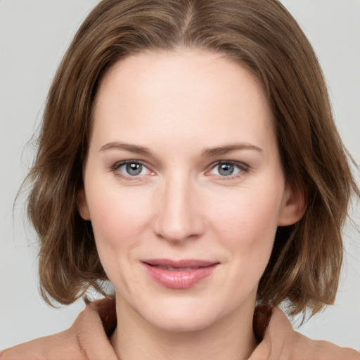 Joyful white young-adult female with medium  brown hair and green eyes