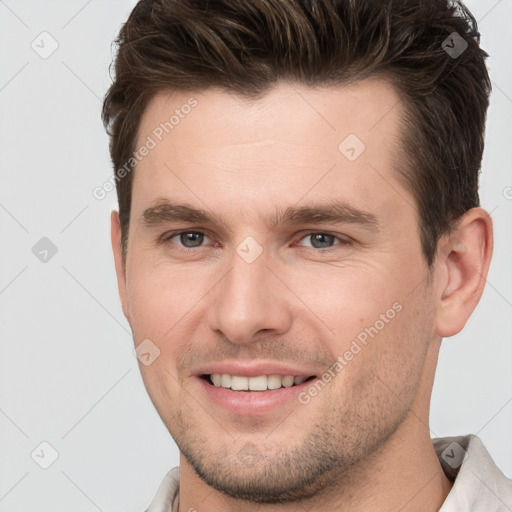 Joyful white young-adult male with short  brown hair and brown eyes