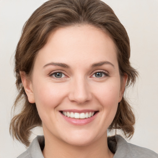 Joyful white young-adult female with medium  brown hair and grey eyes