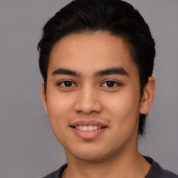 Joyful latino young-adult male with short  black hair and brown eyes