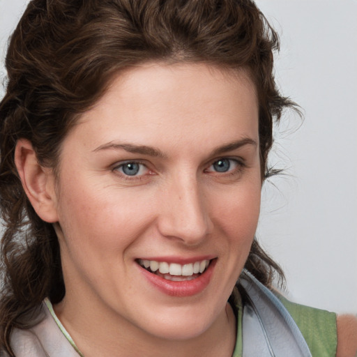 Joyful white young-adult female with medium  brown hair and blue eyes