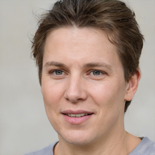 Joyful white young-adult female with short  brown hair and grey eyes