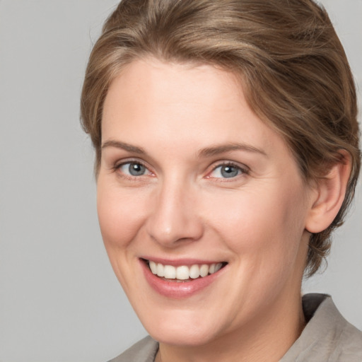 Joyful white adult female with medium  brown hair and grey eyes