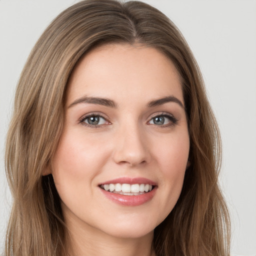 Joyful white young-adult female with long  brown hair and green eyes