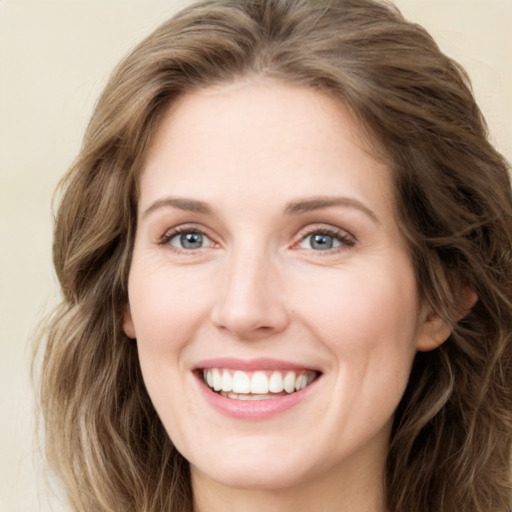 Joyful white young-adult female with long  brown hair and green eyes