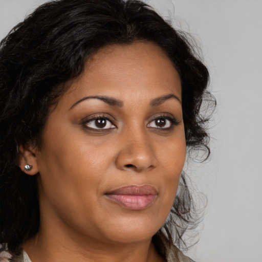 Joyful black young-adult female with long  brown hair and brown eyes