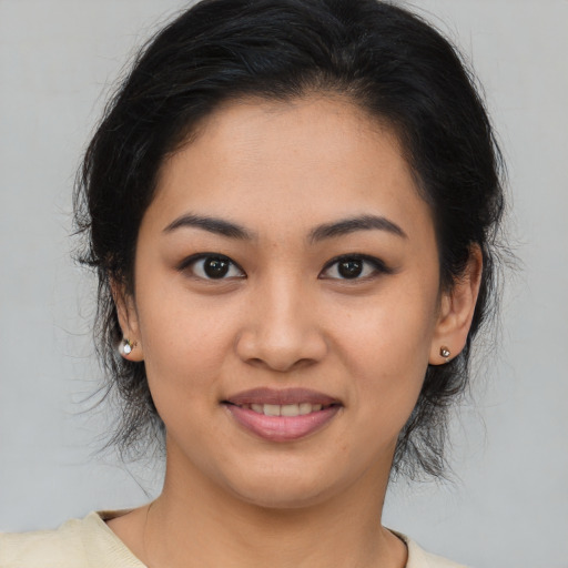 Joyful latino young-adult female with medium  brown hair and brown eyes