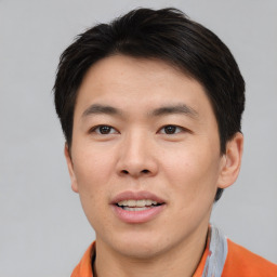 Joyful asian young-adult male with short  brown hair and brown eyes