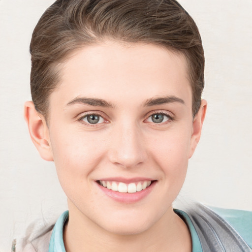 Joyful white young-adult female with short  brown hair and grey eyes