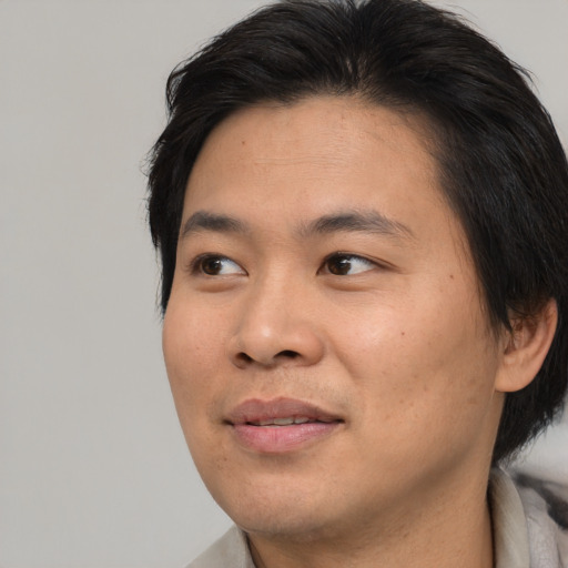 Joyful asian adult male with short  black hair and brown eyes