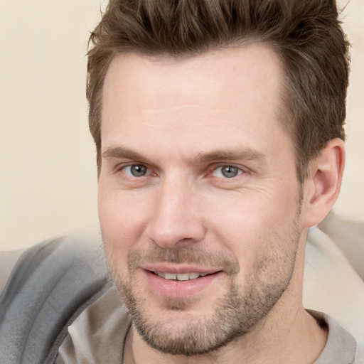 Joyful white young-adult male with short  brown hair and grey eyes