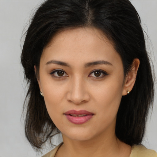 Joyful asian young-adult female with long  brown hair and brown eyes