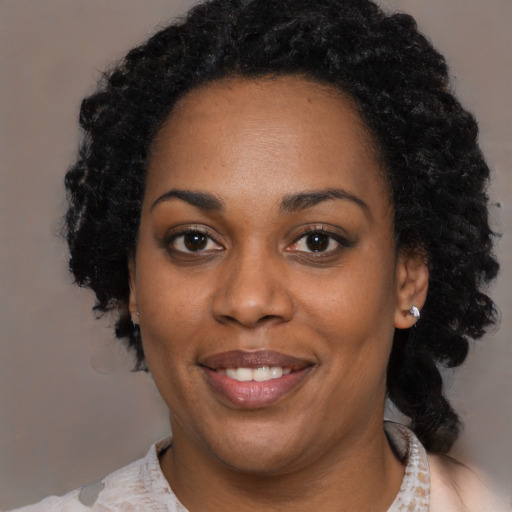 Joyful black young-adult female with medium  black hair and brown eyes