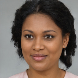 Joyful black young-adult female with medium  brown hair and brown eyes