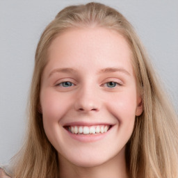 Joyful white young-adult female with long  brown hair and blue eyes