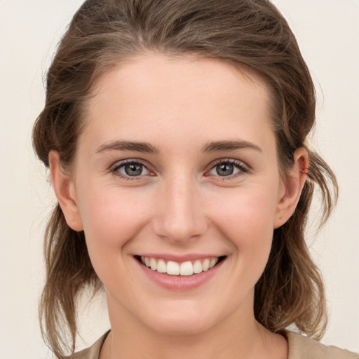 Joyful white young-adult female with medium  brown hair and grey eyes