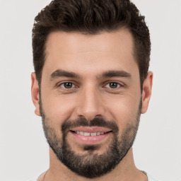 Joyful white young-adult male with short  brown hair and brown eyes