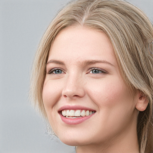 Joyful white young-adult female with long  brown hair and blue eyes