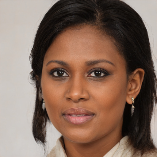 Joyful black young-adult female with medium  brown hair and brown eyes
