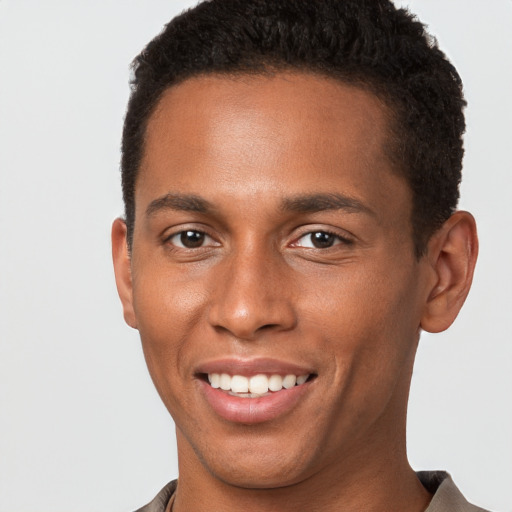 Joyful black young-adult male with short  brown hair and brown eyes