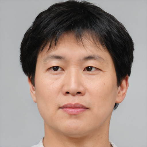 Joyful asian adult male with short  brown hair and brown eyes
